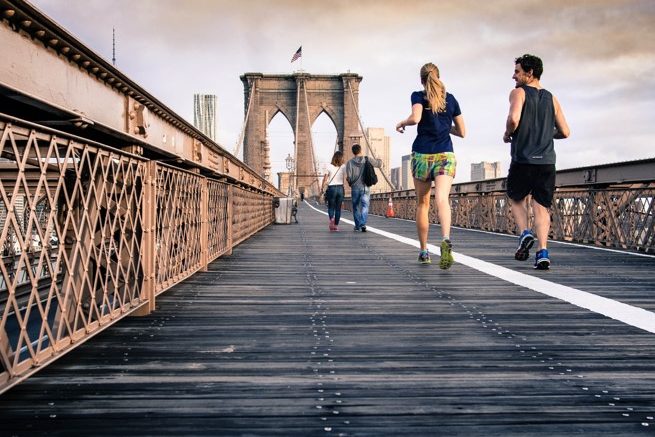 people jogging on bridge